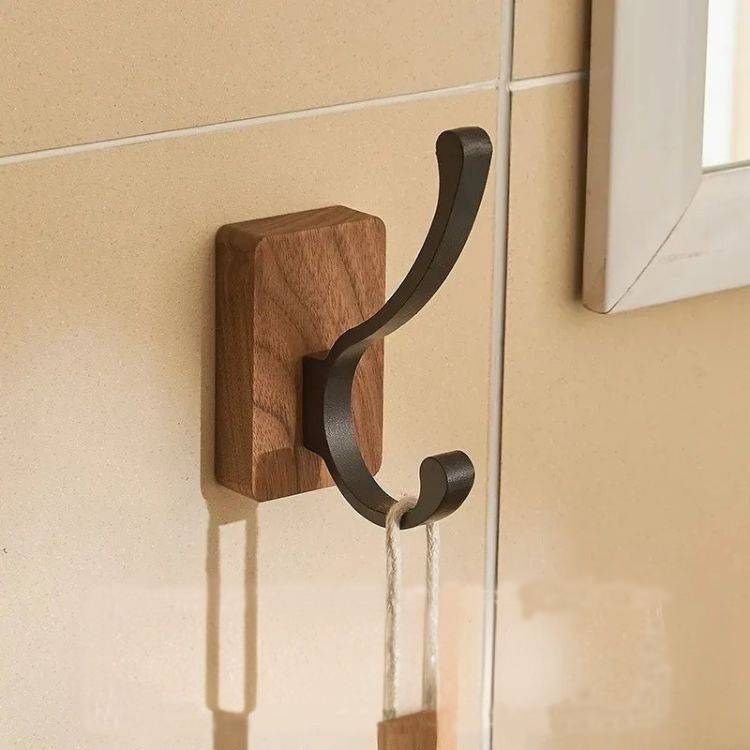 A rectangular wood hook with a black metal double arm.