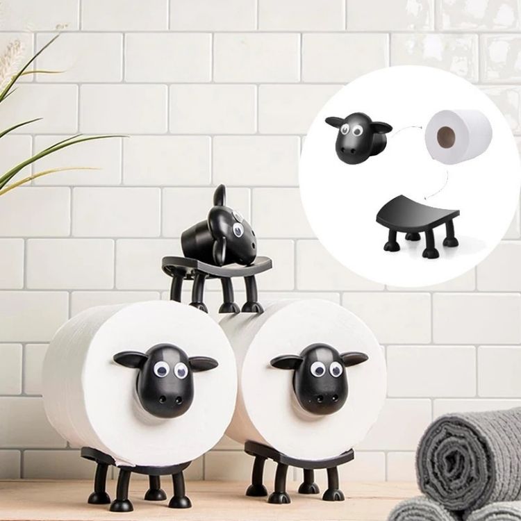A black toilet roll holder mounted on a light wall, holding a roll of toilet paper.