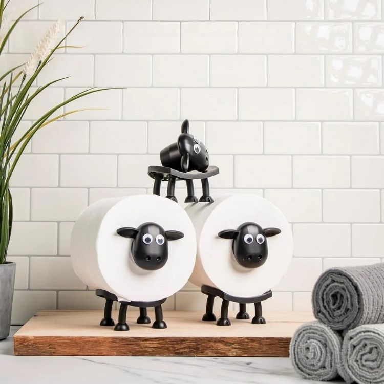 A black toilet roll holder with a top shelf and a roll of toilet paper
