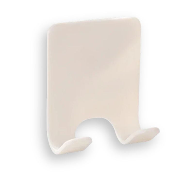 A close-up of a beige adhesive razor holder on a white surface.