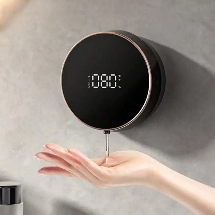 A black smart soap dispenser with a rose gold trim and digital display
