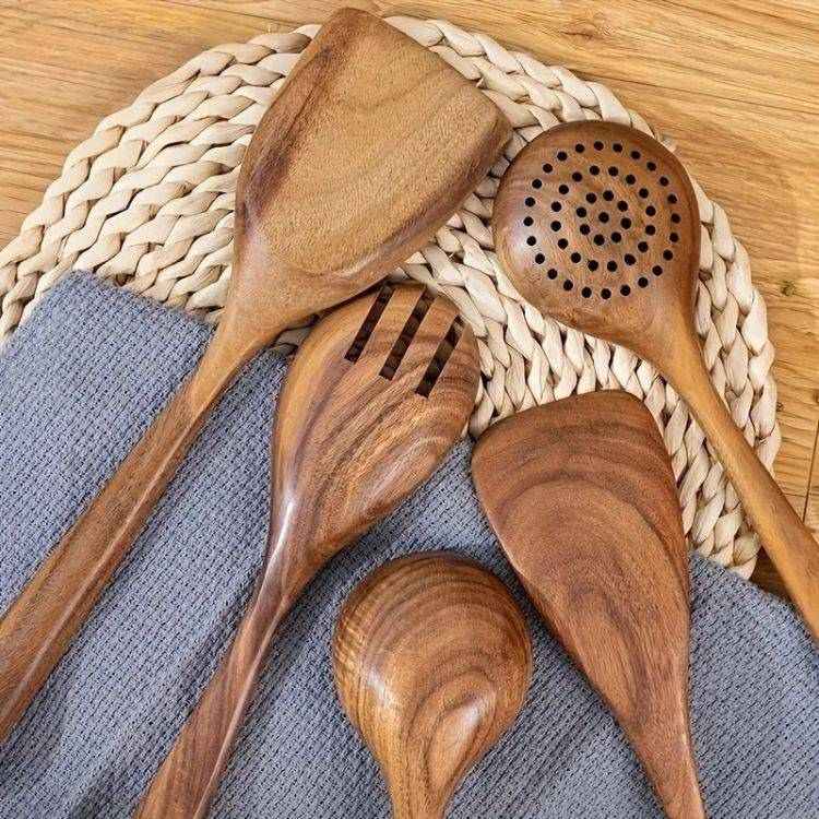 Top view of wooden spoons for cooking on a table with decorative placemat.