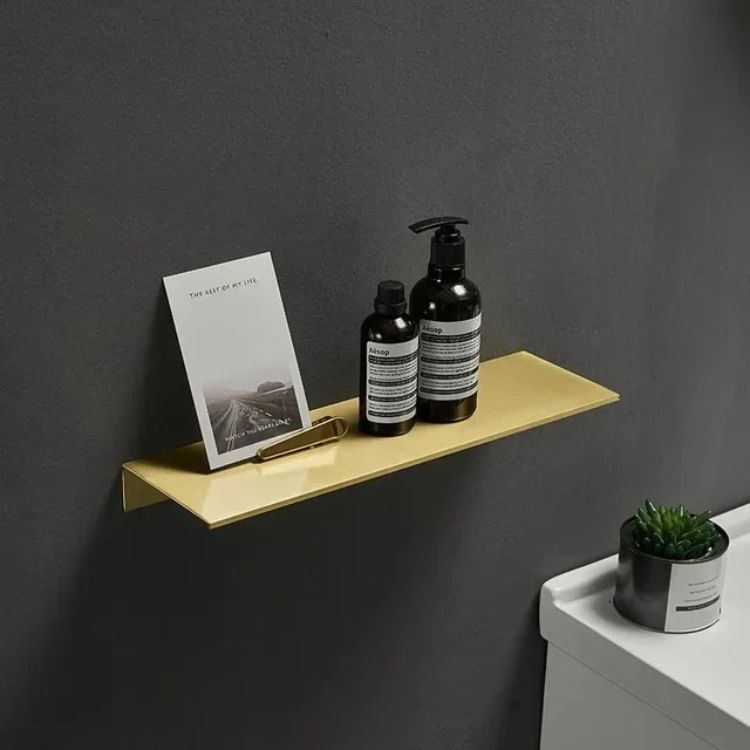 Brushed floating wall shelf styled with elegant decor in white bathroom.