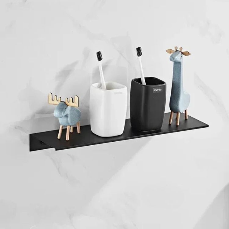 Black floating wall shelf holding black pump bottles and small plant.
