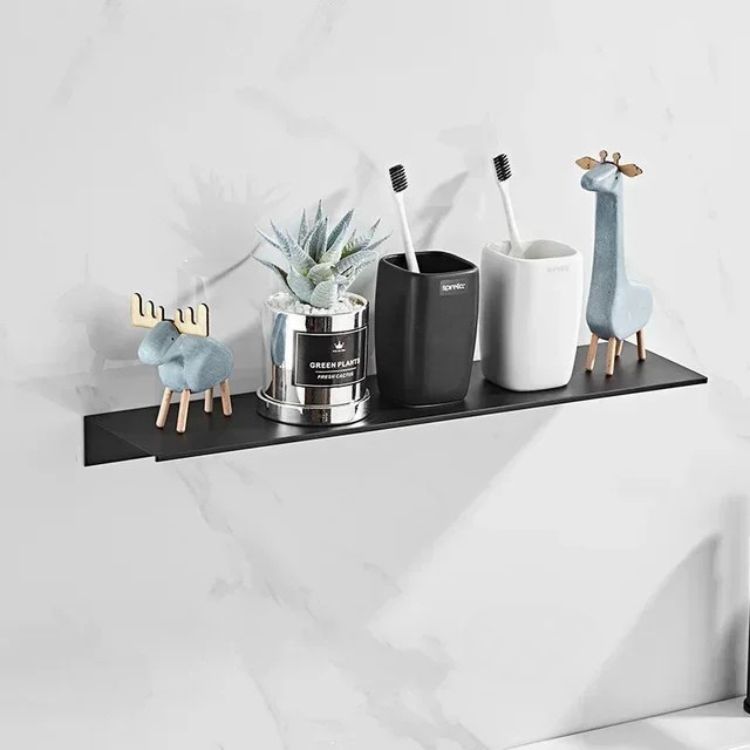 Black floating wall shelf holding soap dispensers and a vase.