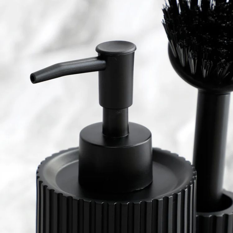 Close-up of a black pump top on a ribbed kitchen detergent dispenser.