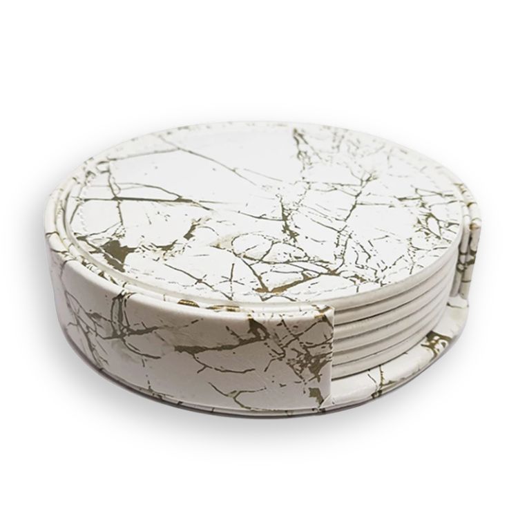 White drink coasters with gold marble lines, stacked in a matching circular holder.