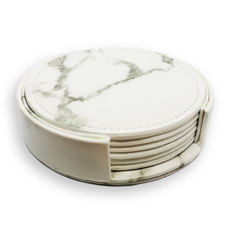 Round white marble-look drink coasters with grey veining, neatly arranged in a matching holder.