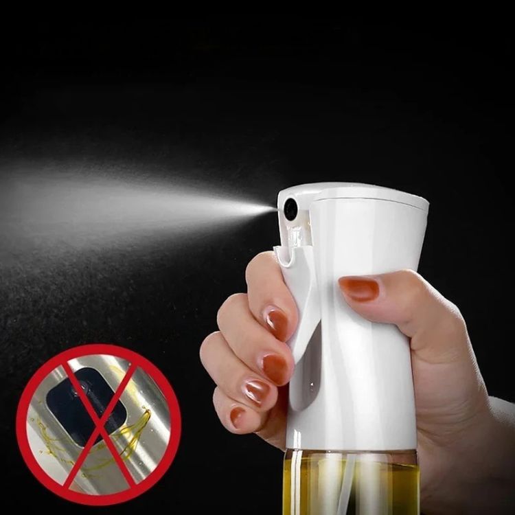 Hand using oil sprayer bottle with a fine mist spray, shown with anti-clog design.