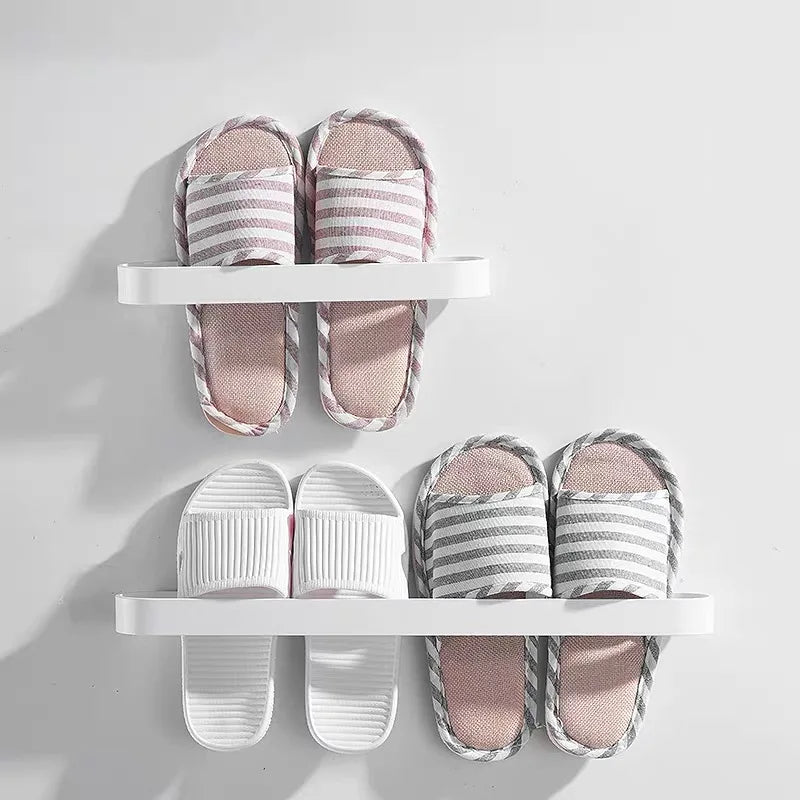 Wall-mounted white racks holding several pairs of slippers in an organized manner.