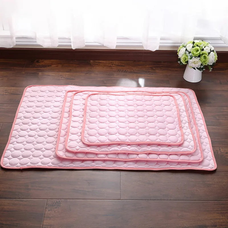 Pink and blue dog cooling mats stacked together.