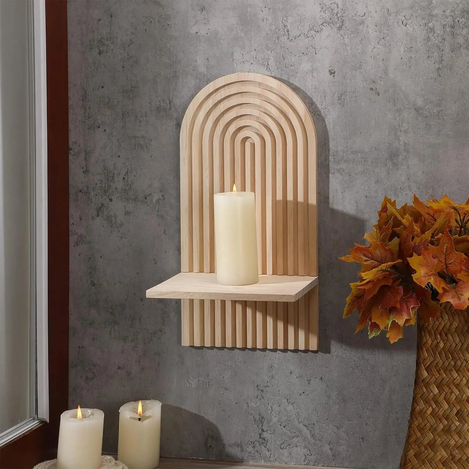Wall-mounted boho shelves with arch detail holding decor against a grey wall.