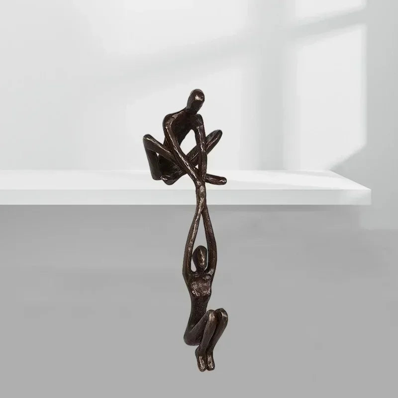 Minimalist shelf with bronze sculpture ornament of two climbing people.
