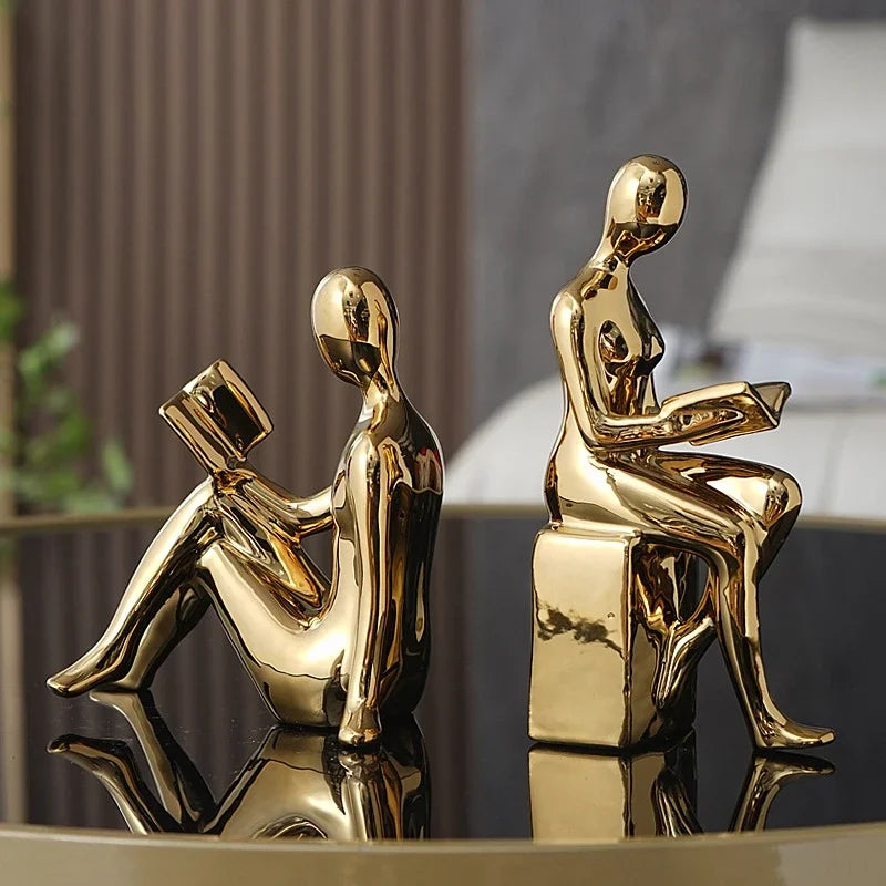 Gold bookshelf stopper with two reading figures seated on either side.