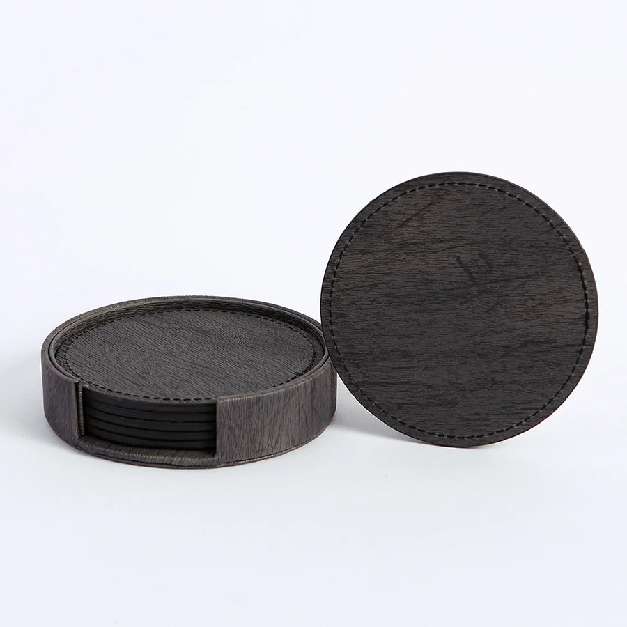 Six dark grey circular wood-grain coasters, stacked in holder, one separate.