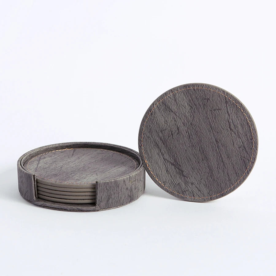 Six dark grey round wood-grain coasters with holder, one separate.