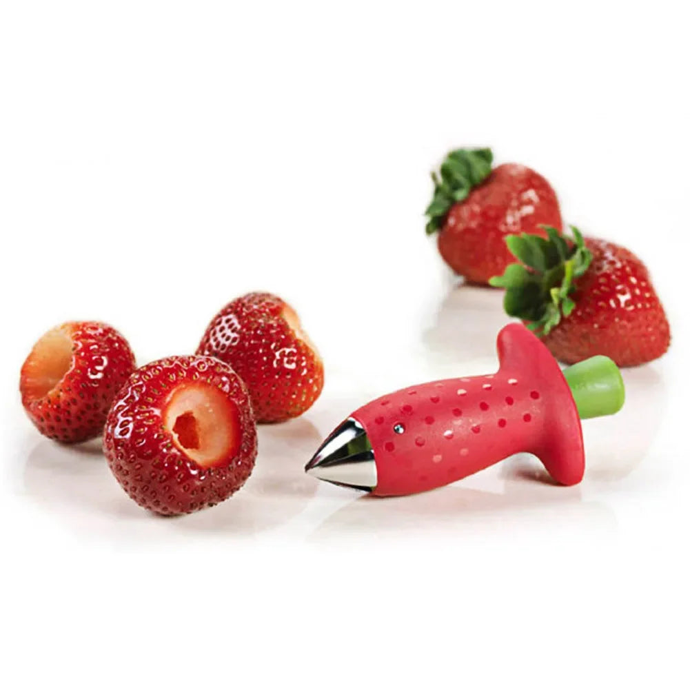 Red fruit corer and cored strawberries on a white background.