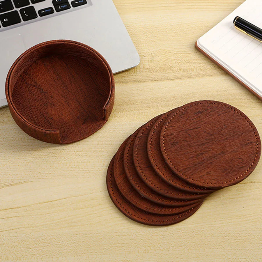 Brown coasters tea set beside a laptop.