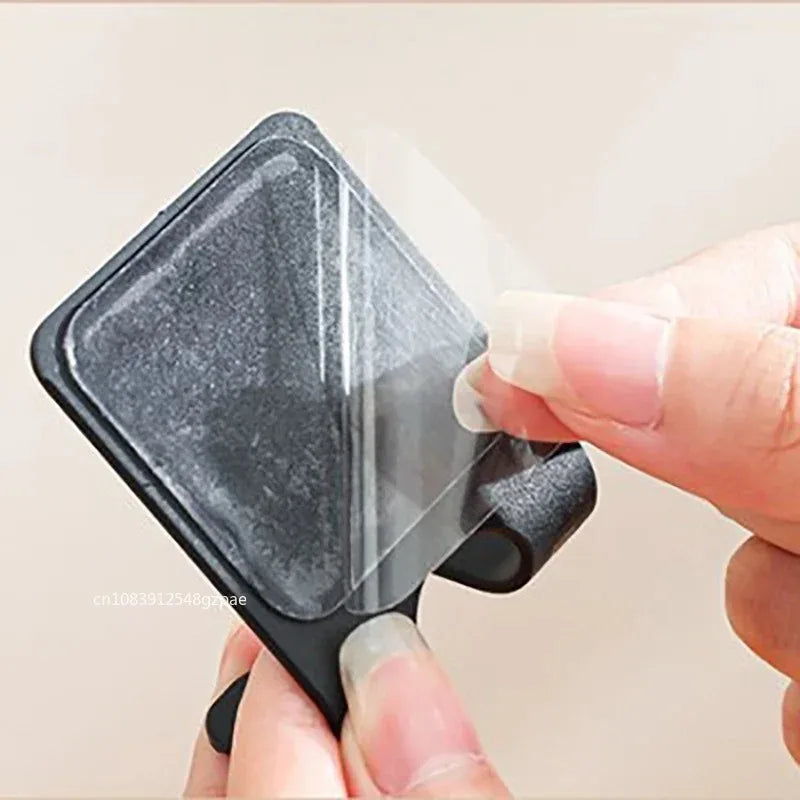A black adhesive razor holder shown in a bathroom setting.