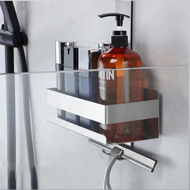 Mounted silver shower shelf on glass panel with bottles.