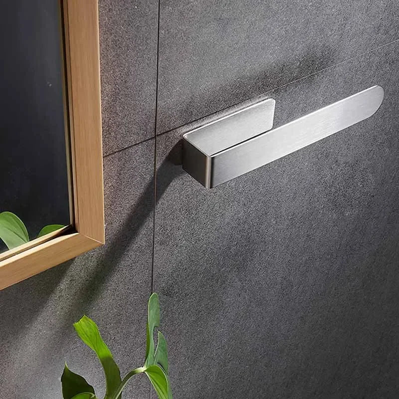 Empty silver adhesive towel ring mounted on wall.
