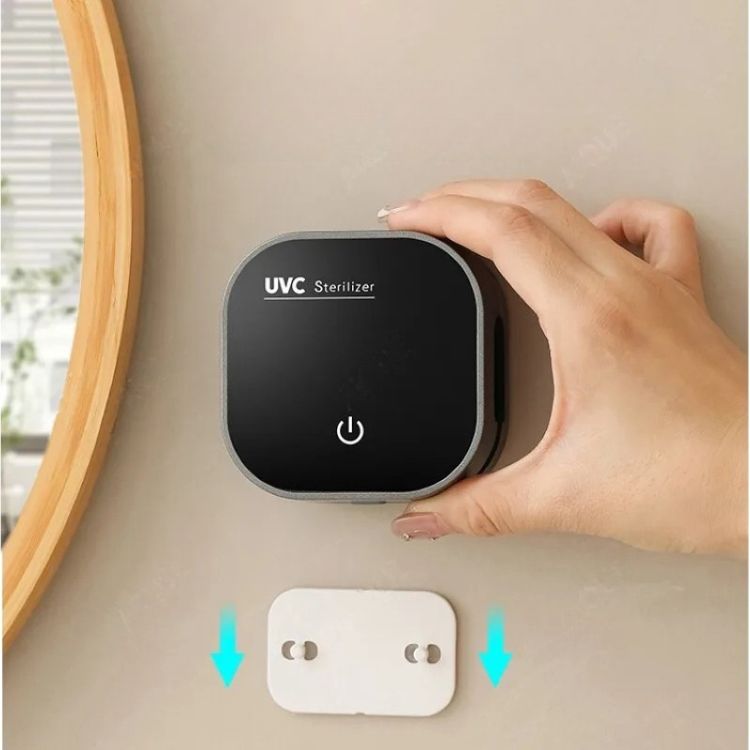 Compact sterilizer case being placed on the wall next to a USB charger