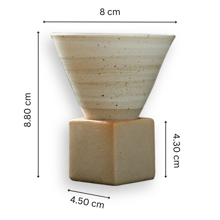 A light-colored, speckled ceramic coffee cup with a conical shape