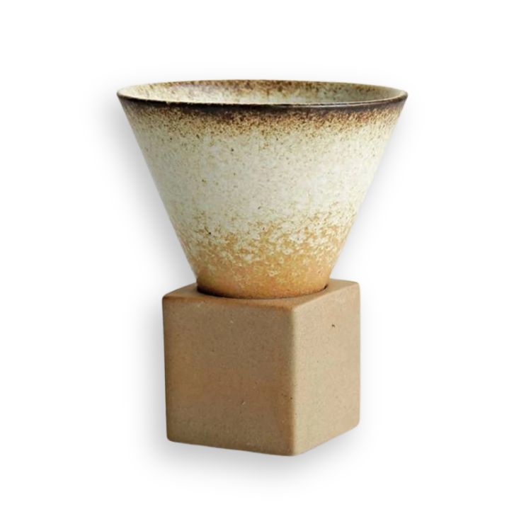 A cream-colored ceramic coffee cup with a brown rim