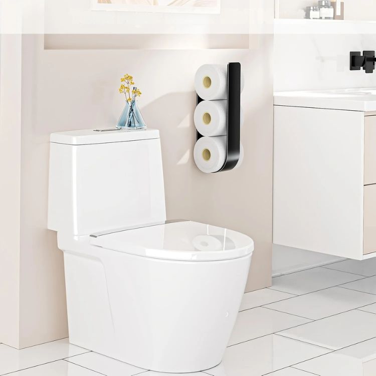 A black wall-mounted toilet paper rack holding three rolls in a modern bathroom.