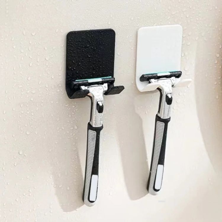 A chrome razor holder with a suction cup, holding a razor.