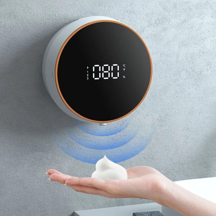 A black smart soap dispenser with rose gold trim and a digital display.