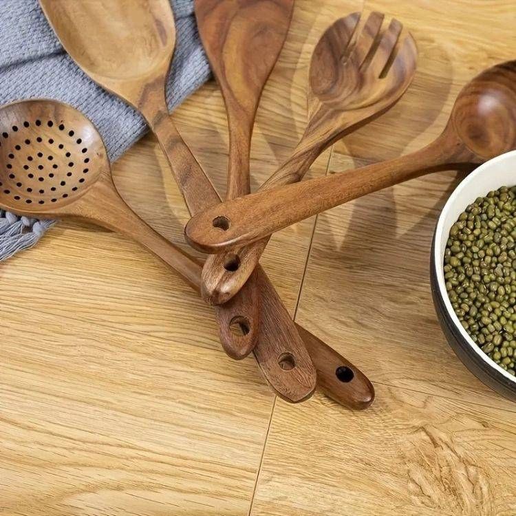 Bundle of wooden spoons for cooking tied with twine on a wooden surface.