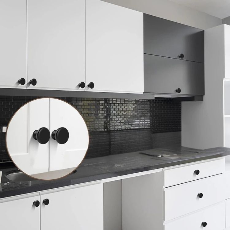 White kitchen cabinets featuring round black kitchen cabinet knobs.