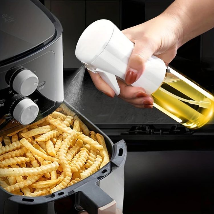 Oil sprayer bottle used to spray fries in an air fryer basket.