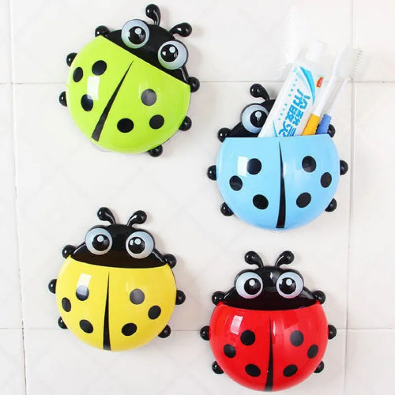 Four ladybug-shaped toothpaste holders in green, blue, yellow, and red