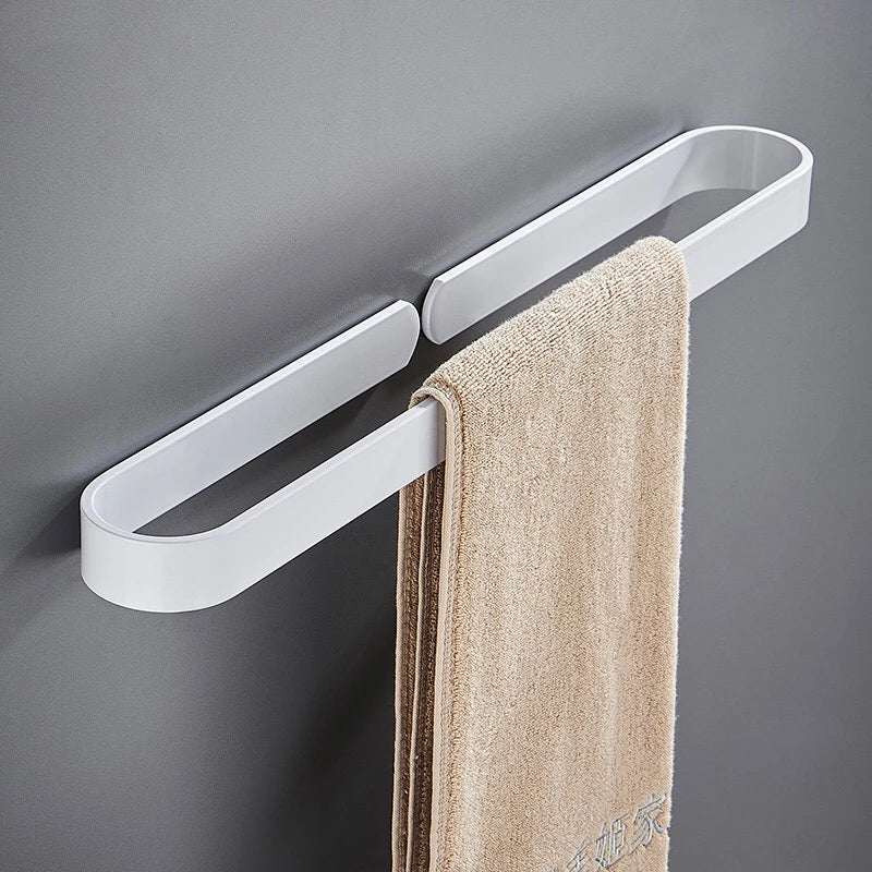 White metal kitchen towel rack on a wall, holding a beige towel.