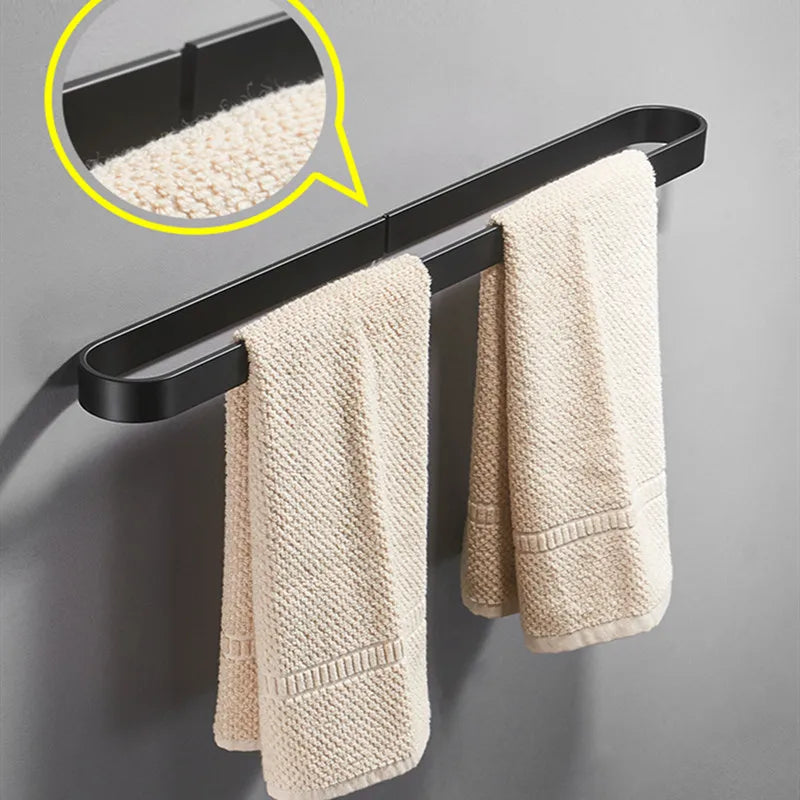 Black kitchen towel rack holding two beige towels