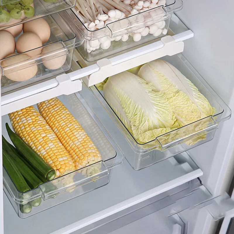 Two refrigerator drawers storing corn, greens, mushrooms, and eggs in a tidy fridge setup.