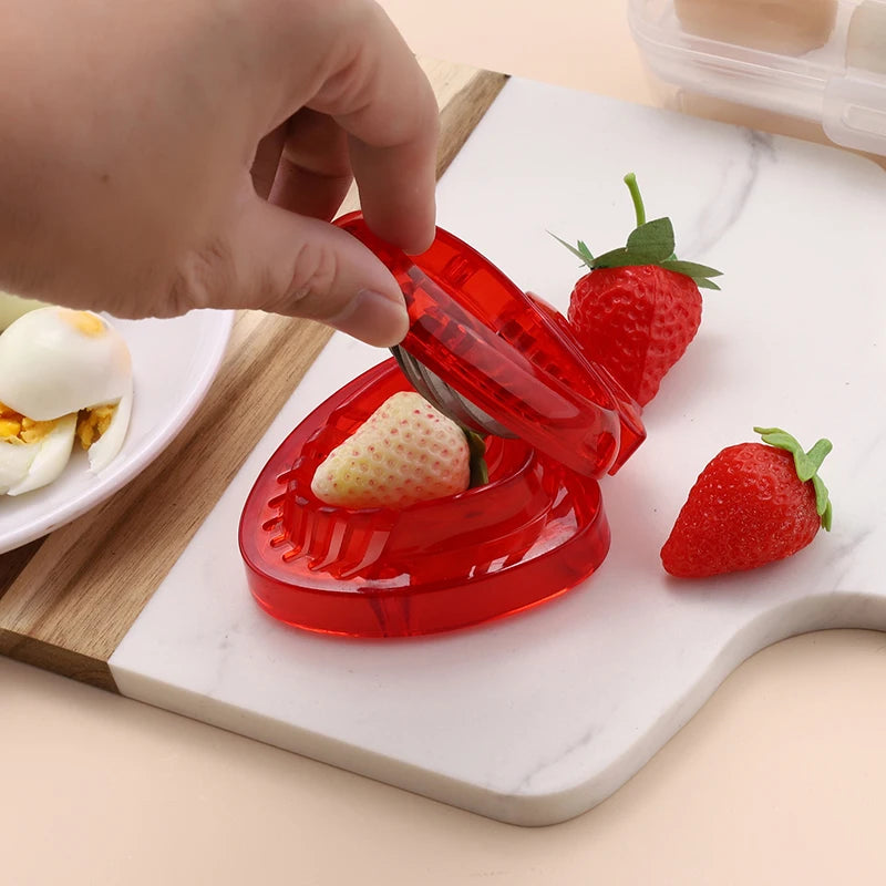 Red, heart-shaped strawberry slicer with dimensions displayed.