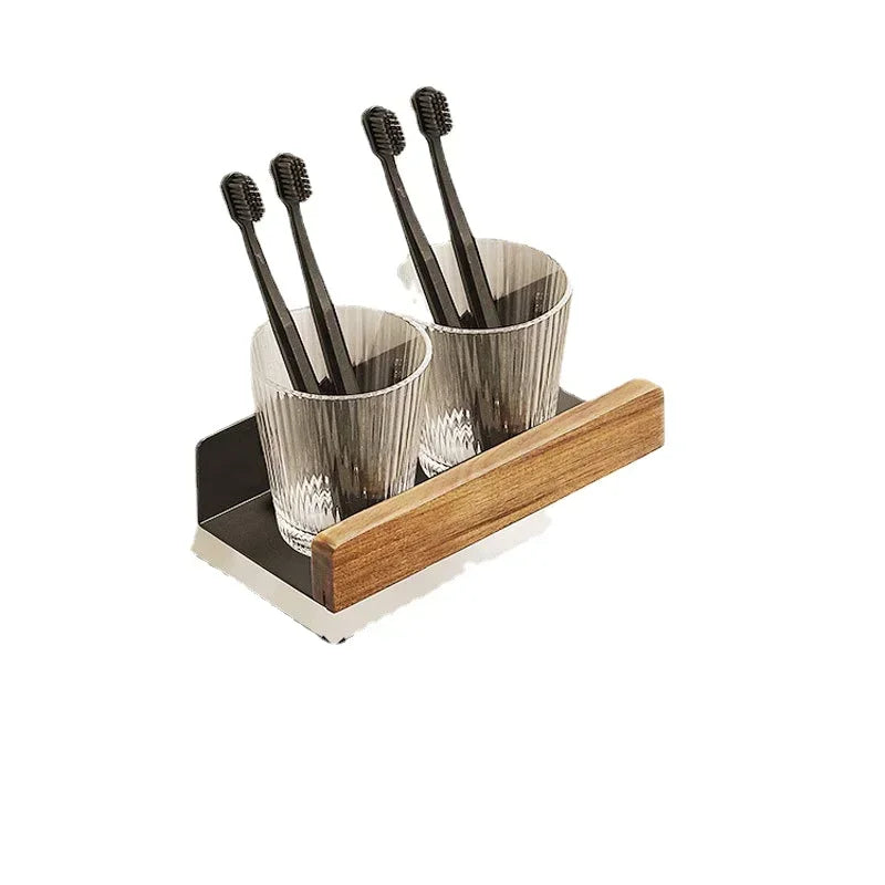 A small floating wood shelf with two cups holding toothbrushes.