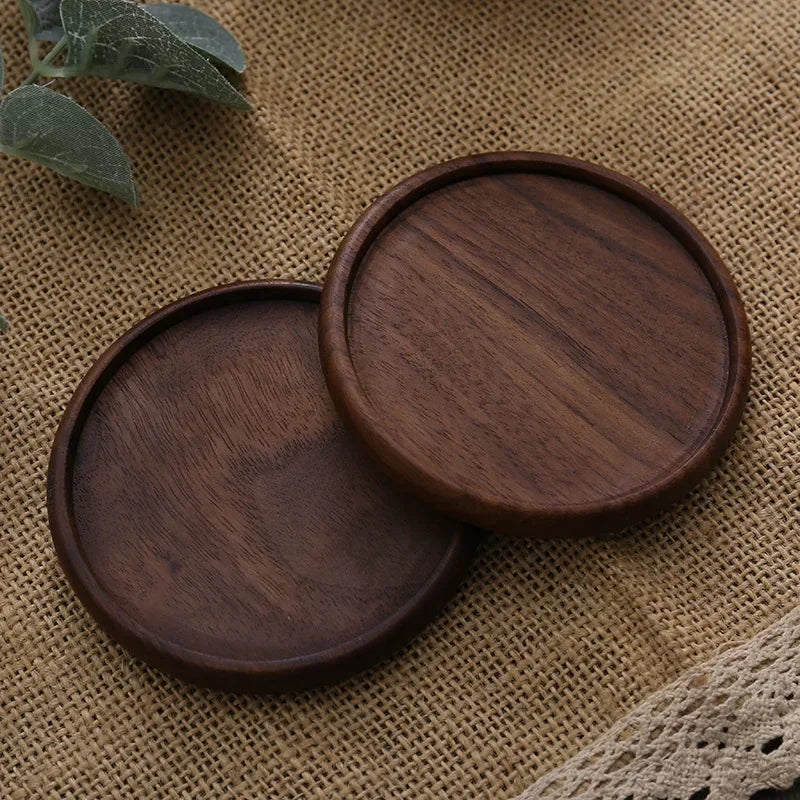 Pair of dark beech round coasters near a tea cup – wooden coaster.
