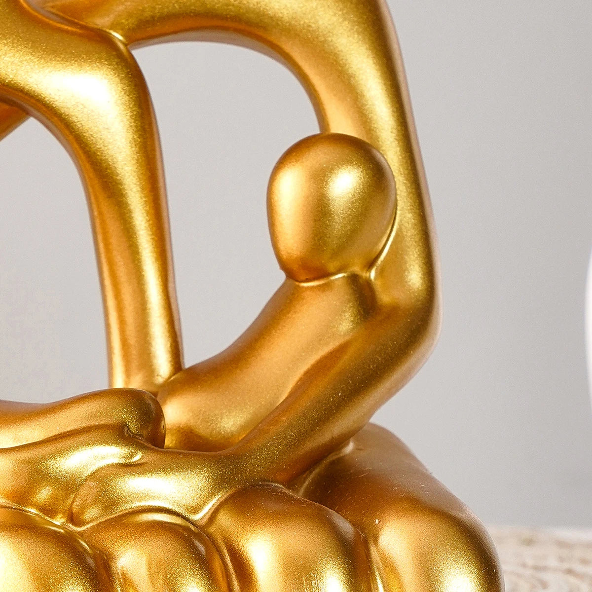 Close-up of golden hugging couple desk statue with smooth finish.