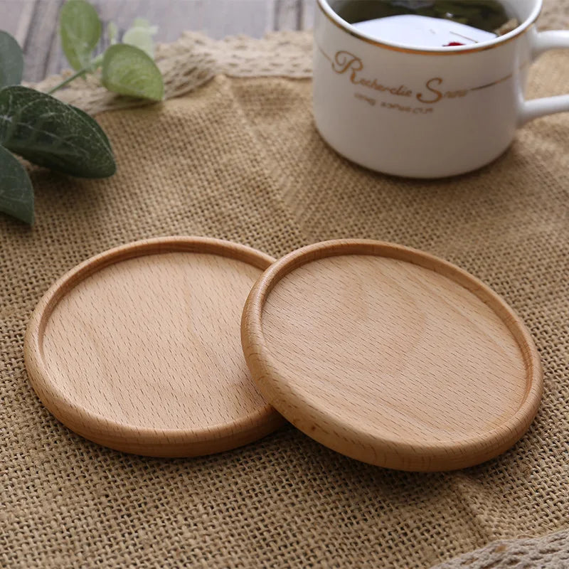 Two light brown round wooden coasters placed on a burlap cloth with a cup in the background.