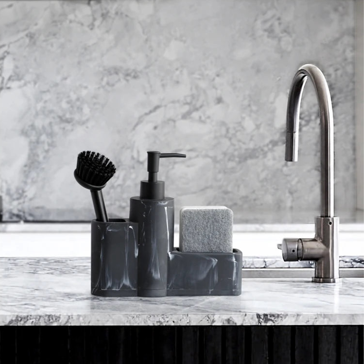 Black marble dish soap dispenser set on a kitchen sink.