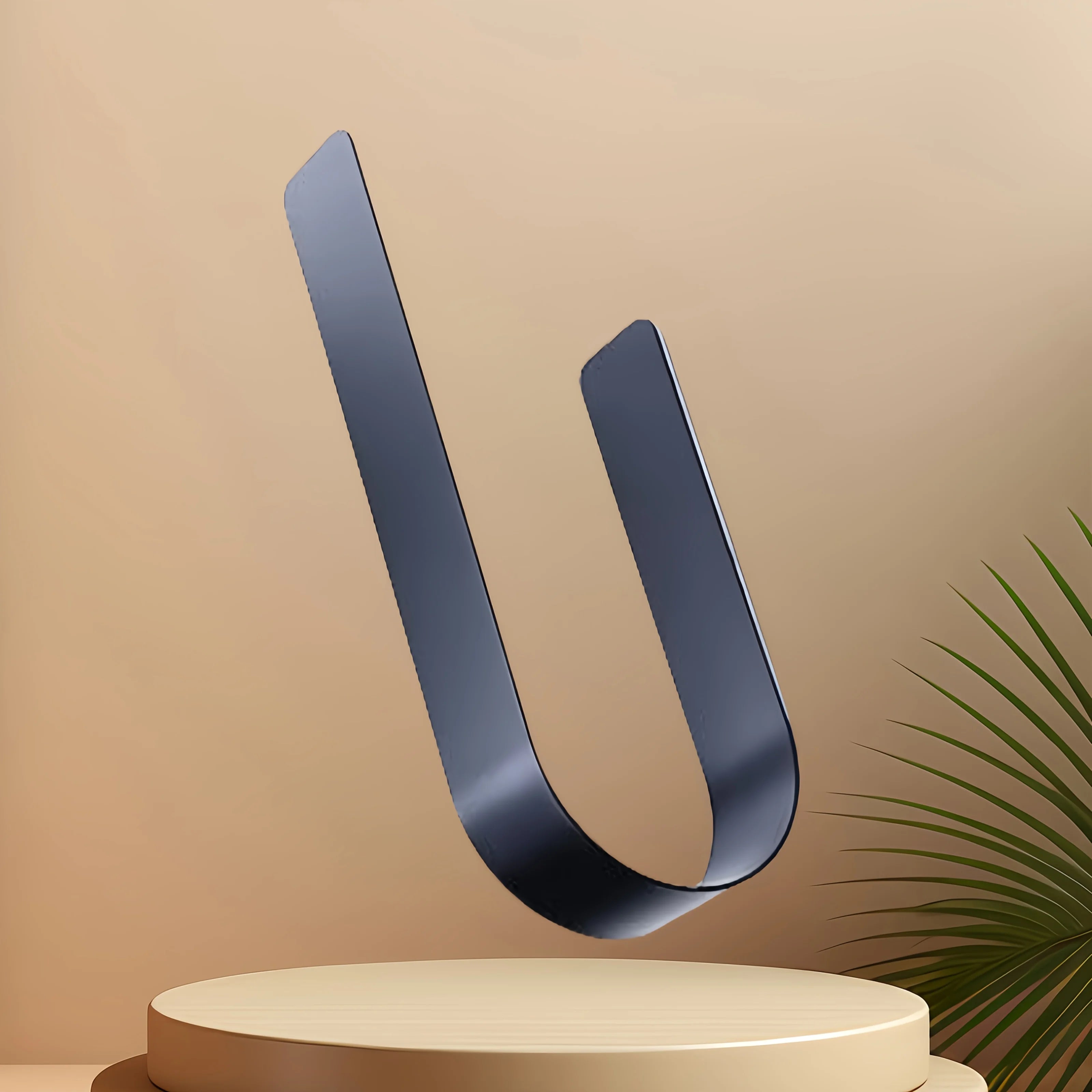A black U-shaped object, resembling a toilet paper rack, on a pedestal.