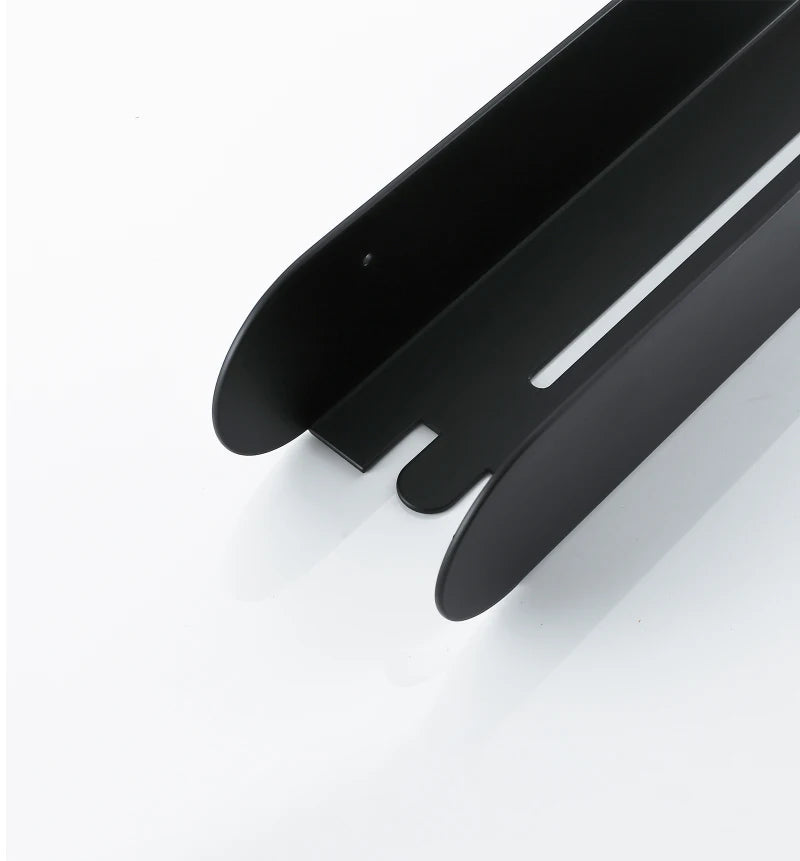 Close-up of the empty black bathroom shelf organizer showing rounded ends and open bottom.
