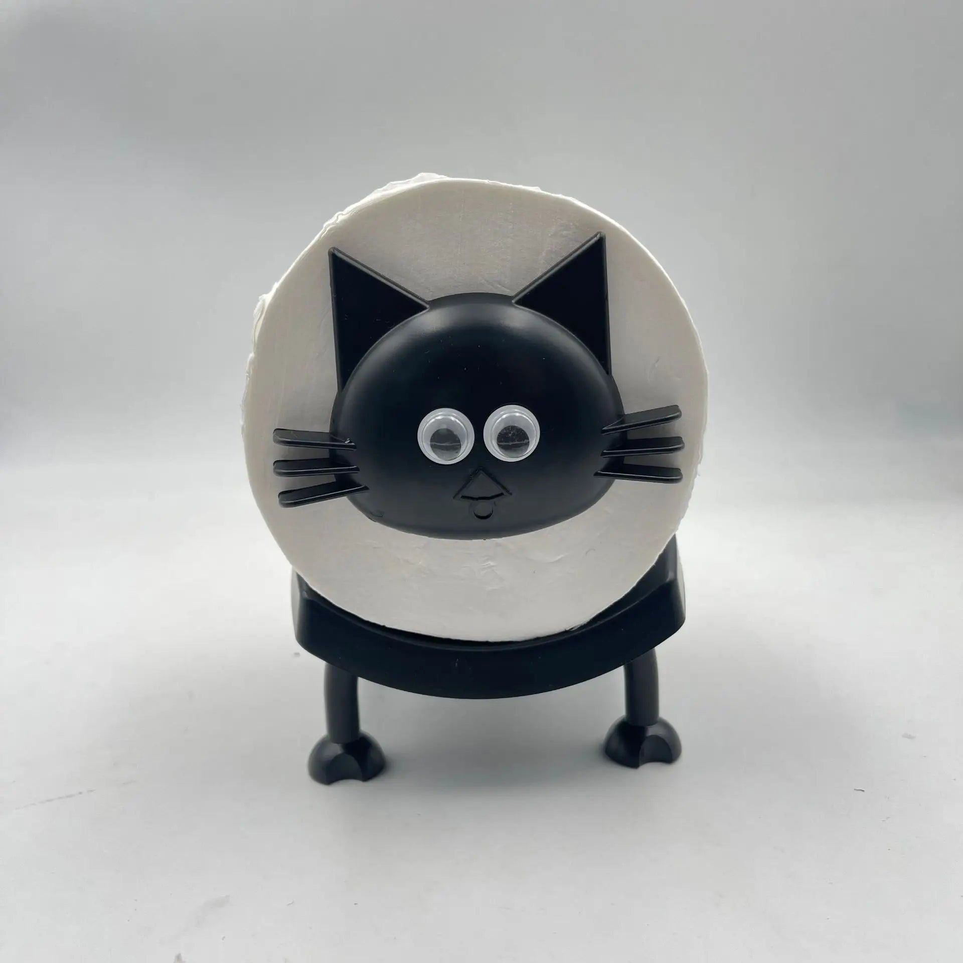 A black toilet roll holder with a top shelf