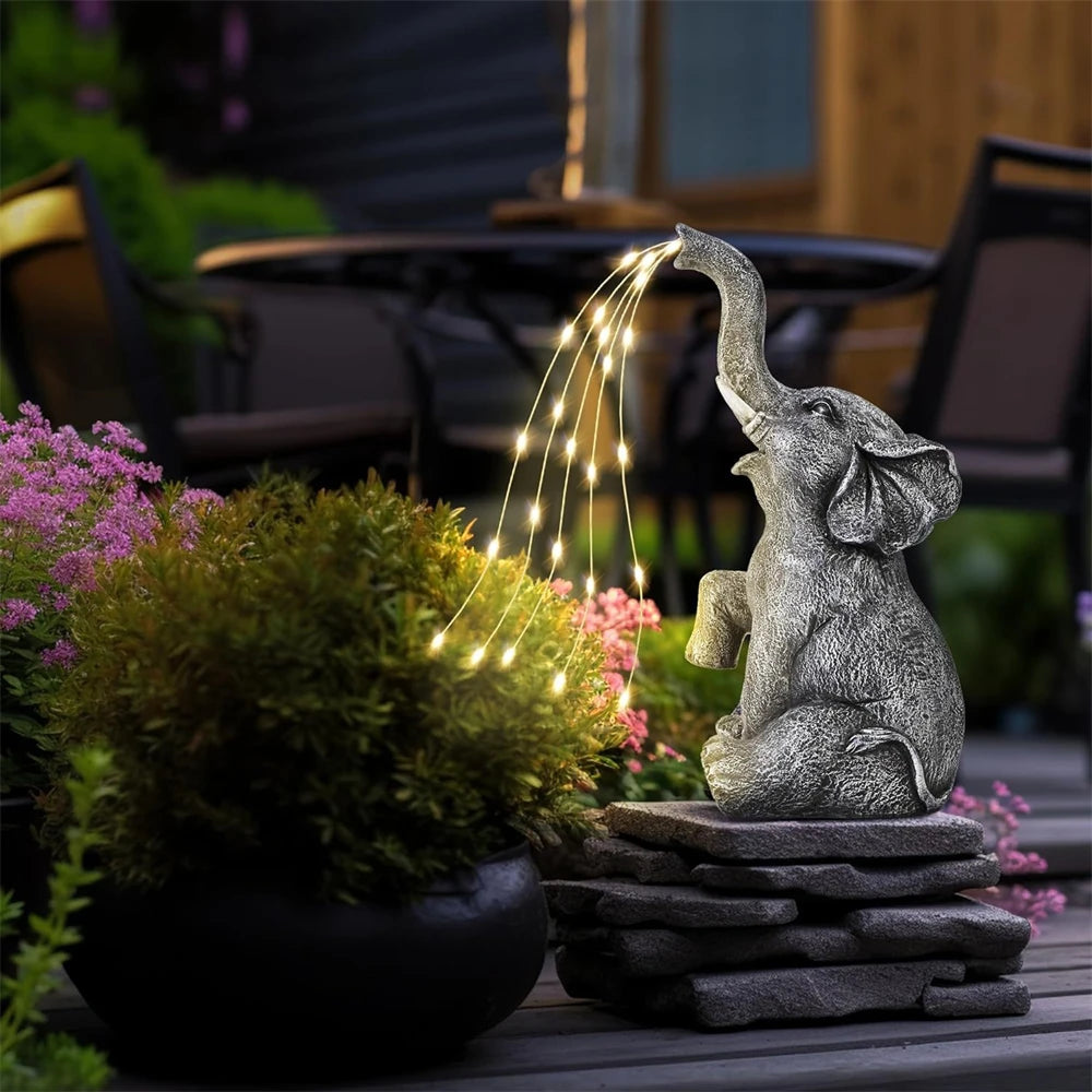 Elephant statues with LED lights on a patio surrounded by plants.