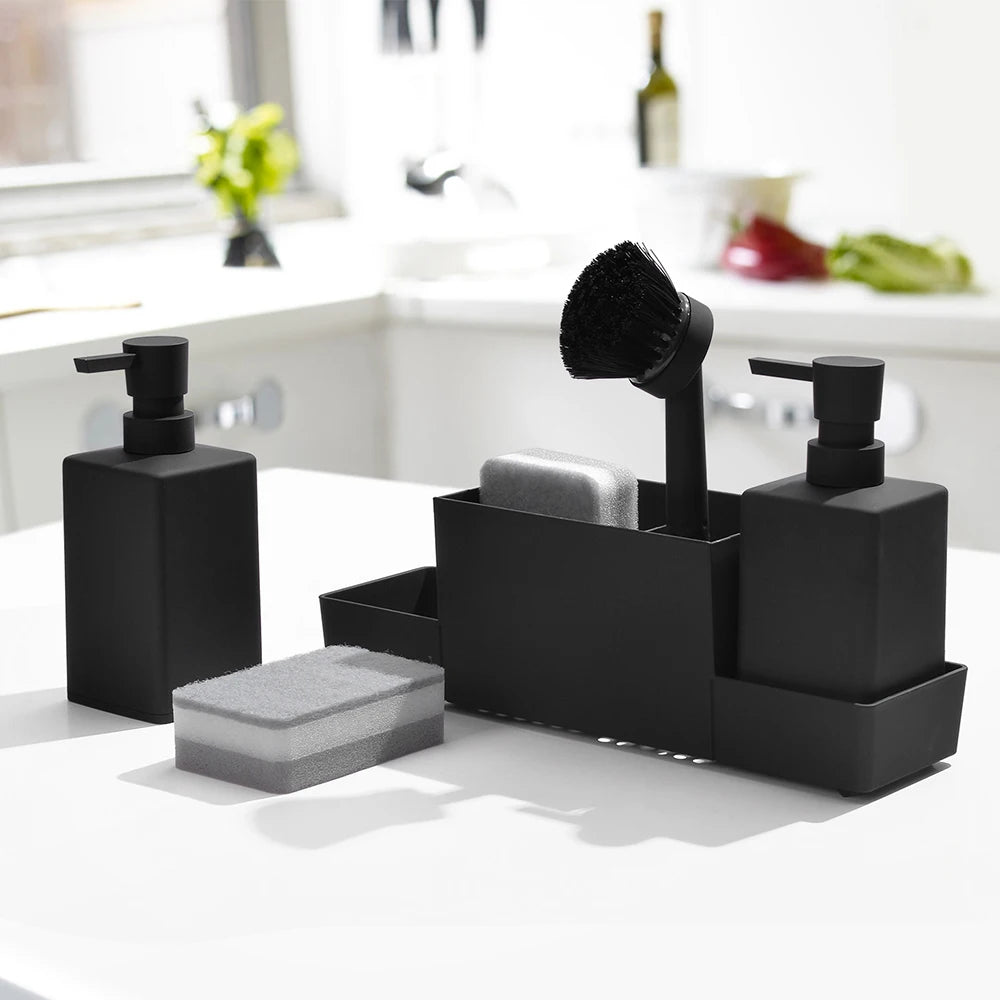 Black sink caddy with soap dispensers and brush on countertop.
