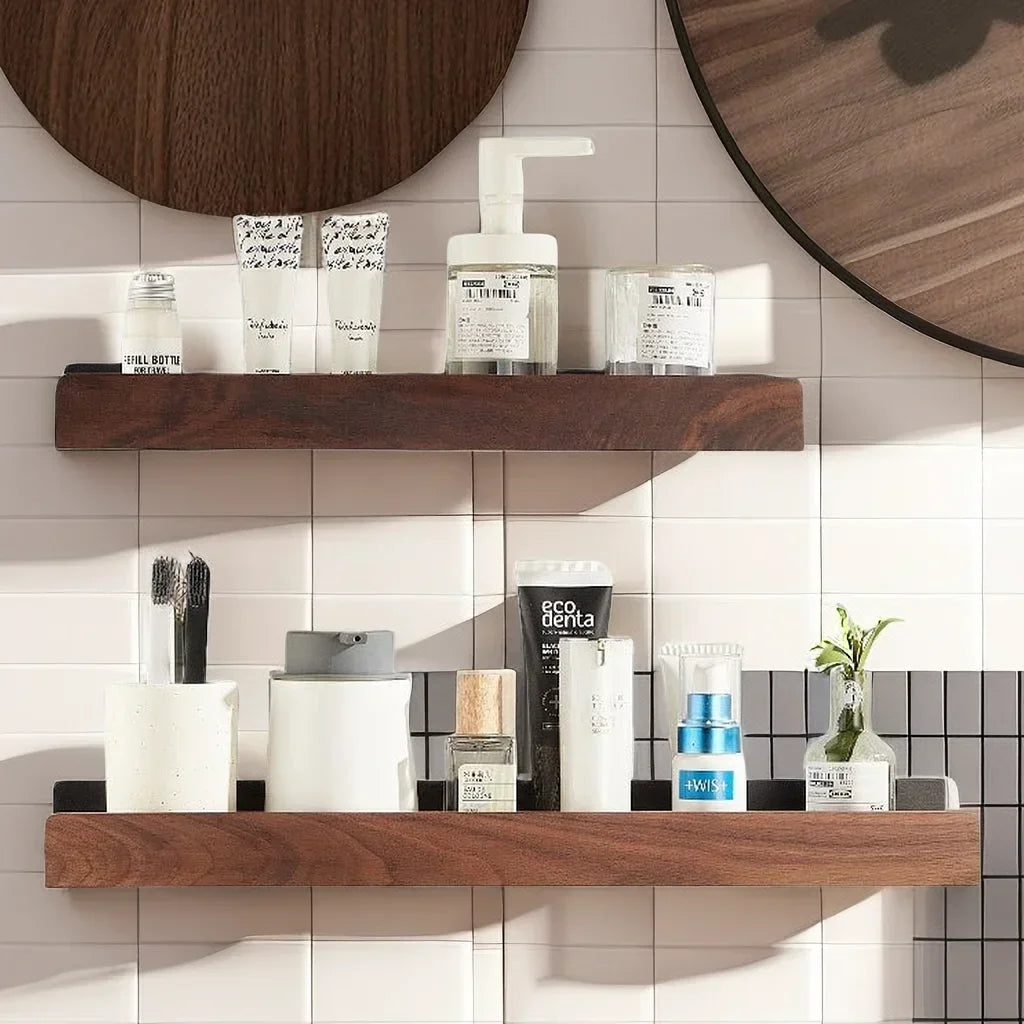 Two floating wood shelves displaying various bathroom toiletries against a tiled wall.